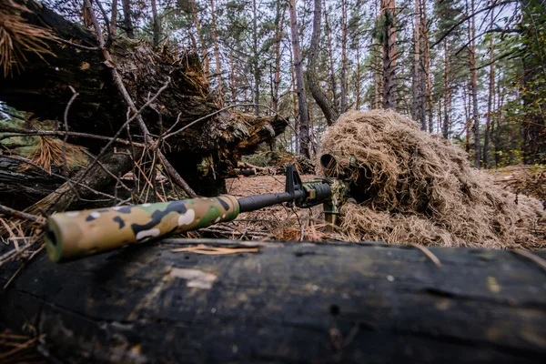 Gecamoufleerde sniper liggend in bos en gericht door middel van zijn toepassingsgebied — Stockfoto