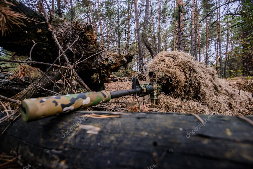 Camouflaged sniper lying in forest and aiming through his scope Stock Photo  by ©Nesterenko_Max 89112398