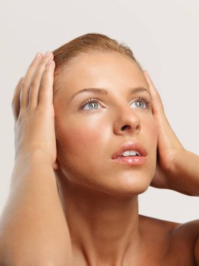 Güzel bir kadının güzel portresi yakın plan başına dokunuyor, ışığa bakıyor.