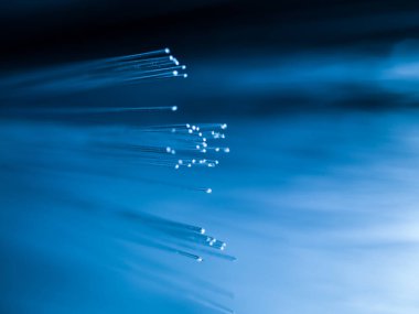 Odaklanamayan arkaplanda parlak mavi fiber optik