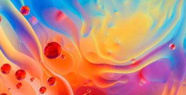 Su yüzeyinde yağ damlaları ve dalgaları olan soyut renkli arkaplan