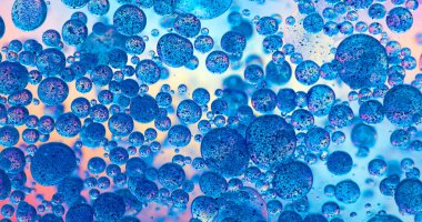 Su yüzeyinde parlak arkaplanlı makro yağ damlası ve pigment