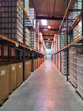 Üç katlı yüksek bir salonun iç perspektifi, bir endüstriyel depoda, raflarda saklanmış ürünler