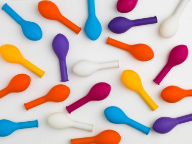 Beyaz arkaplanda renkli sönmüş balonların düzenlenmiş deseni