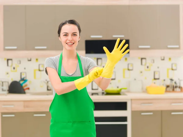 Młoda Szczęśliwa Kobieta Zakładając Gumowe Rękawiczki Przygotowując Się Czyszczenia — Zdjęcie stockowe