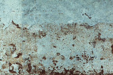 Mavi duvar dokusu pas noktalarıyla bozulmuş.
