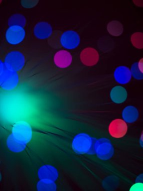 Fiber optik ışık çubuğunun sanatsal makrosu. Yuvarlak şekilli parlak renkli ışık noktaları var.