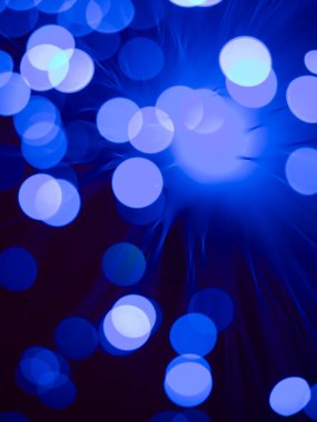 Mavi yuvarlak ışık lekeli, fiber optik ışık değneği makrosu olan soyut duvar kâğıdı