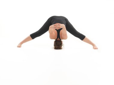 Siyah giyinmiş, beyaz arka planda genç sarışın bir kadın tarafından gösterilen zor yoga pozunun ön görüntüsü