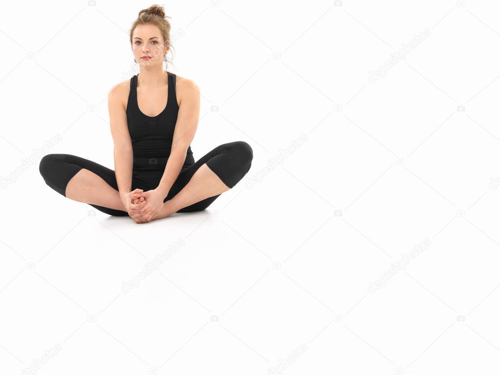 young woman demonstrating yoga pose, full front view, dressed in black, on white background