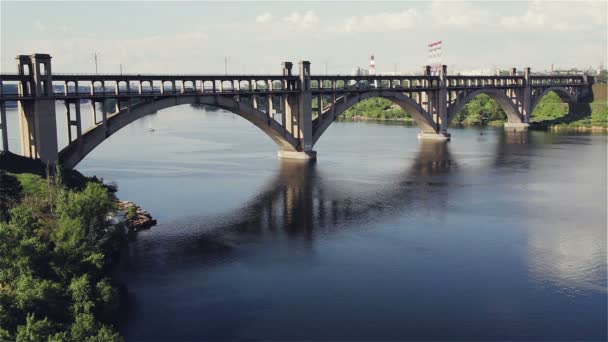 Most přes řeku vodu. Mostem prochází proud autodopravy. — Stock video