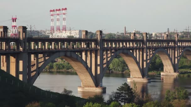 Bridge over river water. The bridge passes a stream of motor transport. — Stock Video