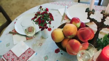 Sofra. Festival tablo meyve, kırmızı balık, bir kadeh şarap ve bir mum.