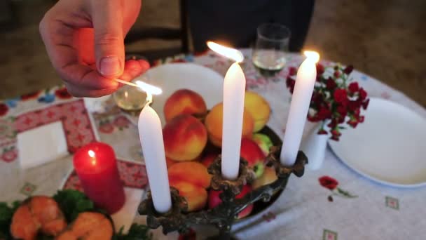 Vajilla. En la mesa festiva fruta, pescado rojo, una copa de vino y una vela . — Vídeo de stock