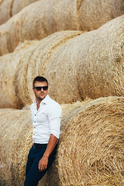 İyi görünüyor saman, güneş gözlüklü genç adam.