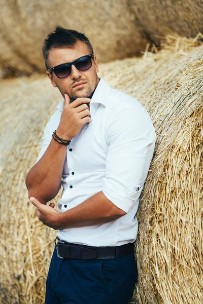 İyi görünüyor saman, güneş gözlüklü genç adam.