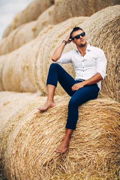 İyi görünüyor saman, güneş gözlüklü genç adam.