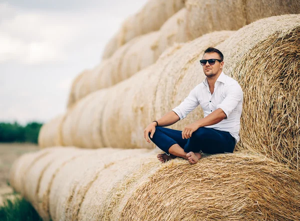 İyi görünüyor saman, güneş gözlüklü genç adam.