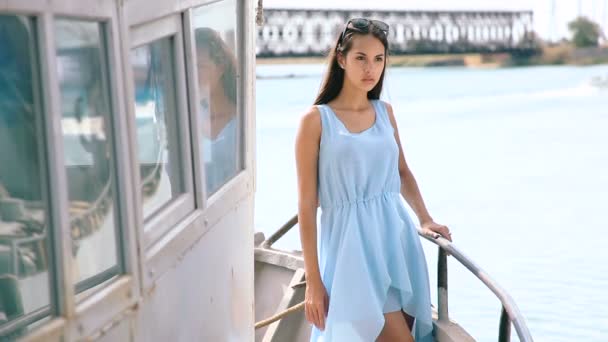 Young girl at the stern of the old vessel. Girl posing on board merchant ships. Brunette on board the boat. Portrait of a girl on the old bridge of the ship. — стокове відео