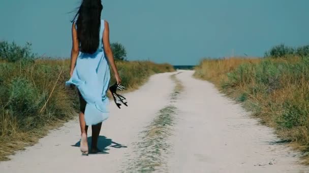 Mince fille va par la route sablonneuse à la plage — Video