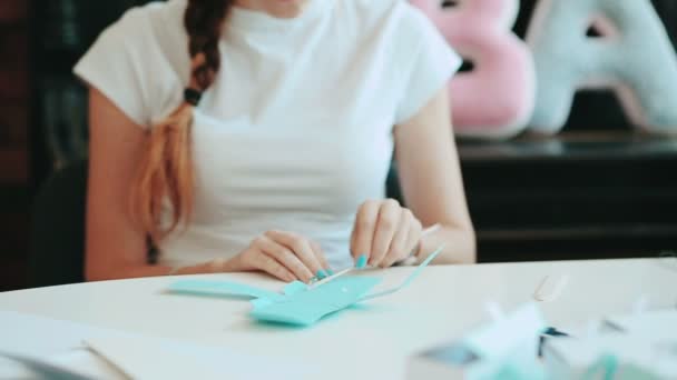 Vrouw maakt doosjes, decoratie, handgemaakte. Gemaakt door handen. Productie van dozen, letters en cijfers. Met de hand naaien. Items voor kinderen en moeders. — Stockvideo