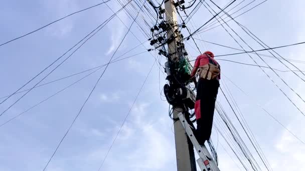 Een elektricien probeert om te gaan met veel draden op een elektrische ondersteuning. — Stockvideo