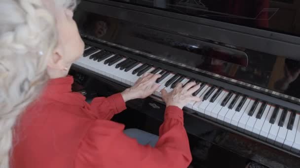 Talentvolle volwassen vrouw speelt muziek op zwarte piano in de kamer — Stockvideo