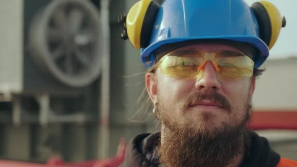 Elektrisch station werknemer met lange baard staat tegen ventilator — Stockvideo