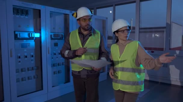 Power station engineers walk past sensor control cabinets — Stock Video