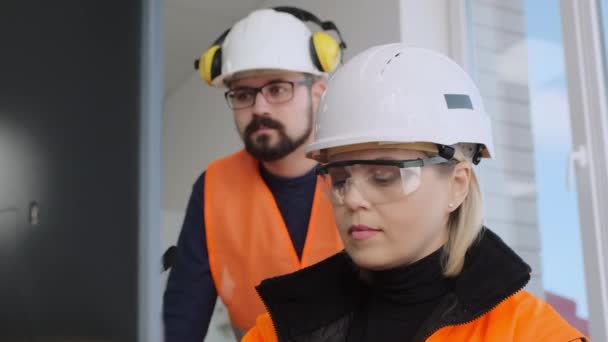 Ingenieur werkt op de computer terwijl collega staat in de buurt — Stockvideo