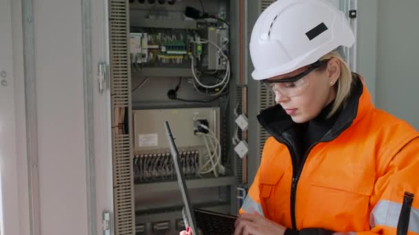 Uśmiechnięty technik sprawdza dane z centrali za pomocą laptopa — Wideo stockowe