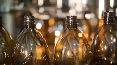 Taze bira için boş plastik şişeler konveyörle taşınıyor.