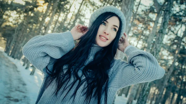 Jonge vrouw in dennenbos in de winter — Stockfoto