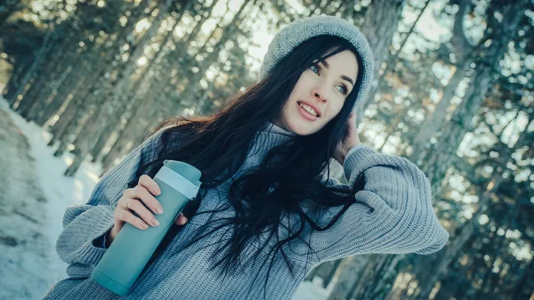 Giovane donna in una pineta con una tazza termica tra le mani — Foto Stock