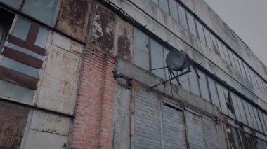 Duvarında sabit bir spot ışığı olan harap bir fabrika zemininin cephesi.