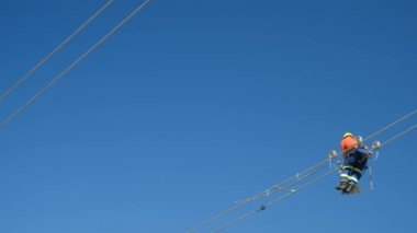 İşçi elektrik kablolarındaki havacılık işaretleyici topları tamir ediyor