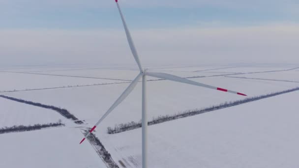 Čepele větrných turbín s červenými pruhy otáčejí zasněžená pole — Stock video