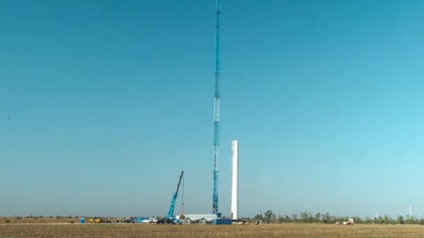 Grúa pone detalle para montar pilar generador eólico en campo — Vídeos de Stock