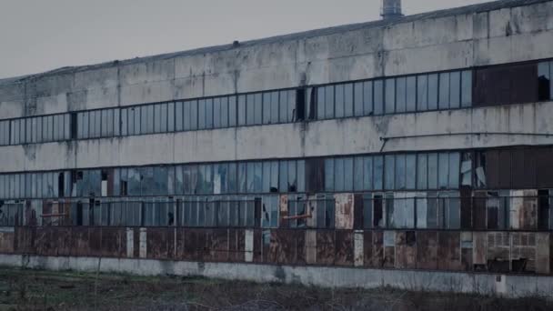 La facciata di una vecchia fabbrica fatiscente con finestre rotte. — Video Stock