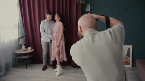 Guy touches tummy of pregnant woman posing for camera — Stock Video