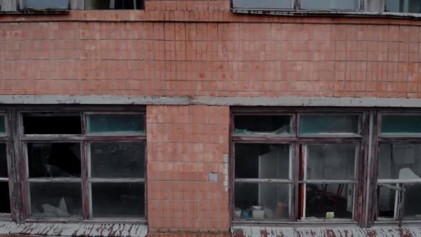 Törött keret és törött üveg egy nagy ablak, vörös téglafal — Stock videók