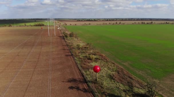 Σήμα μπαλόνια λευκό και κόκκινο σε μια γραμμή μεταφοράς υψηλής τάσης — Αρχείο Βίντεο