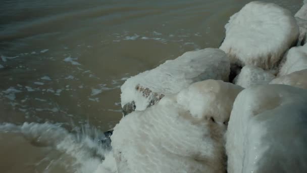 Stora stenhögar täckta med blank is på flodstranden — Stockvideo