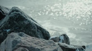 Buzlu taş denizin arka planında karla kaplı.