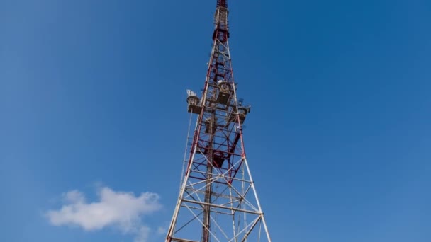 Torre de TV se encuentra bajo el cielo azul con nubes flotantes — Vídeo de stock