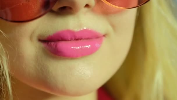 Mujer con lápiz labial rosa en gafas de sol posa para la cámara — Vídeos de Stock