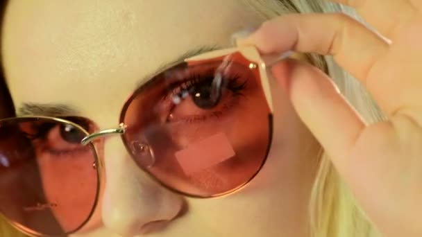 Спокуслива жінка знімає великі сонцезахисні окуляри позує на камеру — стокове відео