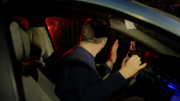 Fahrer im Pullover hebt Hände mit leerer Alkoholflasche — Stockvideo