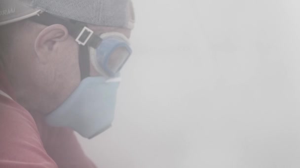 Bygherre i respirator og briller skærer skyttegrave i væggen – Stock-video