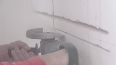 Builder cuts old wall with powerful circular saw at repair